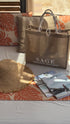 Sage Aesthetic Wellness tote bag with straw sunhat and travel magazines on luxury resort daybed, Scottsdale spa and travel style