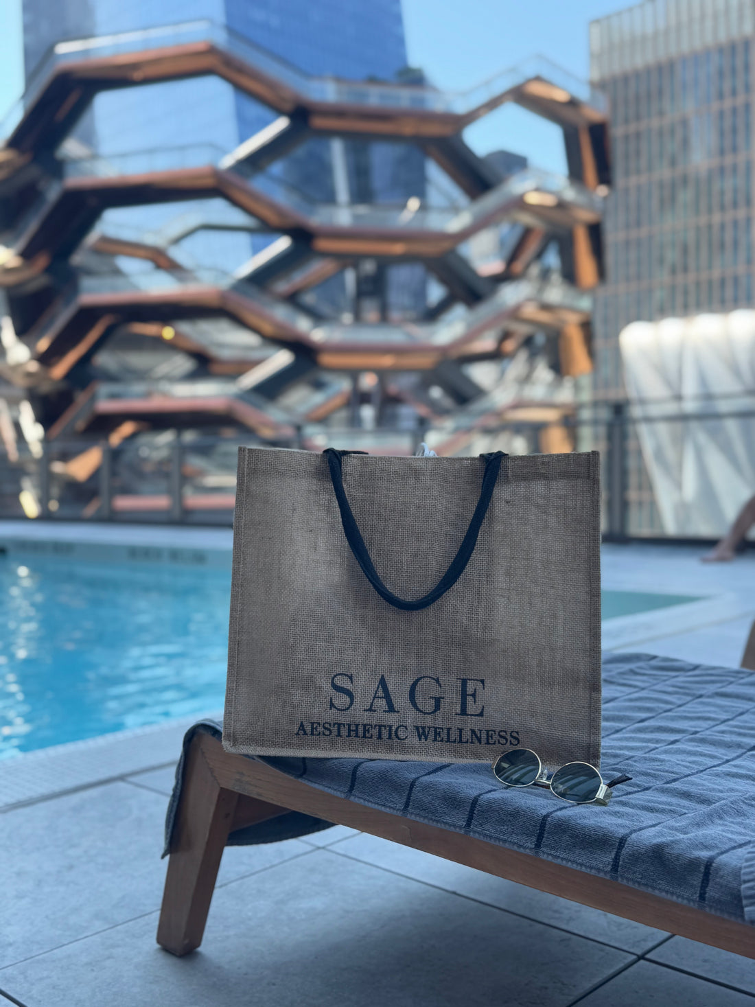 Sage Aesthetic Wellness tote bag with sunglasses on lounge chair by rooftop pool and Vessel NYC, Scottsdale luxury spa lifestyle