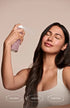 Woman with clear glowing skin using hypochlorous acid face mist, fragrance-free vegan skincare for sensitive skin barrier support