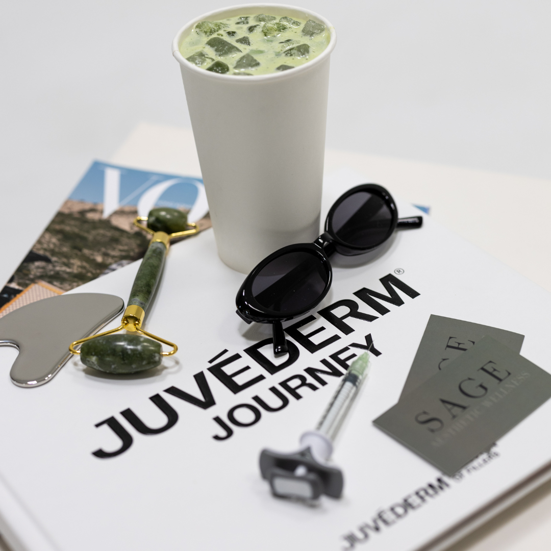 Matcha drink, sunglasses, jade roller, and skincare tools on Juvederm Journey booklet at Sage Aesthetic Wellness Phoenix
